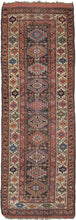 NW Persian Antique Kurdish colorful runner featuring a column of memling güls in bright oranges, soft ivories, and yellows over a deep brown field filled with rows of rosettes and a few stray dogs. Pops of color in blues, reds, and greens on the scrolling border complete the palette. 