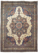 Oversized Lavar Kerman rug featuring features an intricate and well-composed central medallion with a curvilinear floral design and scalloped cornices of cool ivory field. Two teardrop medallions drip into an ivory field which is sparsely decorated with cheerful standalone rosettes. The cornices are distinct but have a continuous feel with the large central medallion, each composed of blossoming vines twisting and turning on a Bordeaux backdrop.