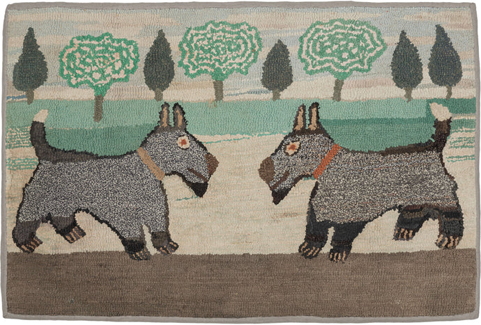 This American Hooked rug was handhooked in New England during the first quarter of the 20th century (1900-1925).  It features a pictorial design of two confronting dogs against a backdrop of trees. Wonderfully folky with a simple but effective use of perspective. The same pf dog is featured but subtle differences like the color of the collar and the different shape of the faces highlight the handmade nature and unique character that is desired in these pieces.