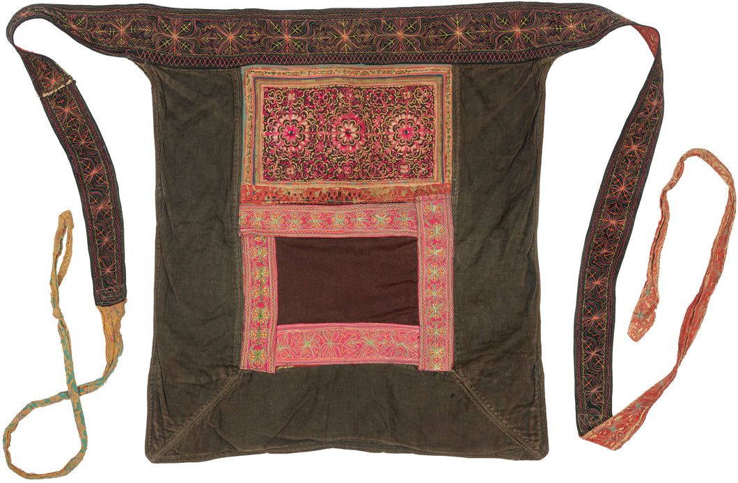 A richly embroidered baby carrier from the Xa Phang people, dating to the mid to late 20th century. Made from dark cotton cloth with appliqué, embroidery, and pieced textile panels, it combines vivid color with a strong graphic structure.

Among the Xa Phang, baby carriers are both practical and deeply personal objects. They allow a mother to keep her child close throughout daily life, from the fields to the market to ceremonial settings. At the same time, they offer a highly visible expression of textile s