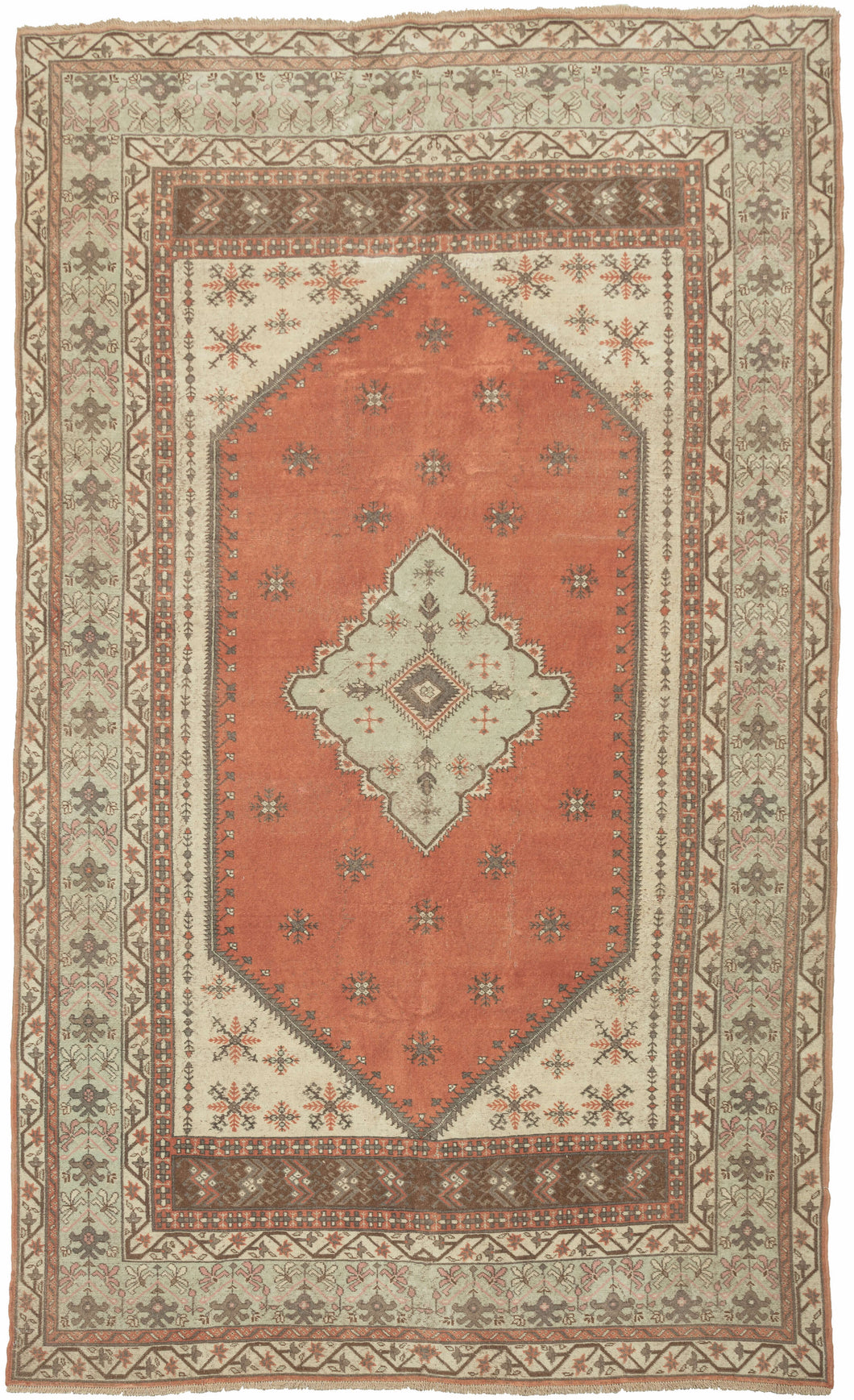 This vintage anatolian rug features a seafoam medallion on a burnt orange ground with ivory cornices. The field and cornices feature well-structured and nicely spaced burr-like forms. The main border features vegetal forms on the same seafoam ground as the central medallion is sandwiched between matching minor borders of scrolling blossoming vines on an ivory ground.  