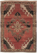 Vintage Anatolian Rug features an ornate central medallion on an open raspberry ground. The four graphic cornices feature layers of wave-like latchooks accentuating the strength of the medallion. Framed by a border of scrolling unfurled tendrils.