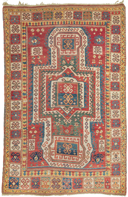 This Sewan Kazak was woven in the Caucasus during the 19th century. 

It features a variation of the classic rendition of the sewan design found in the Caucasus. The strong shield-like medallion is rendered here with a more boxier variation in a rich red, jade, indigo and an cheerful yellow. It is framed by latchooked filled sqaures that coordinate perfectly with the squarish medallion