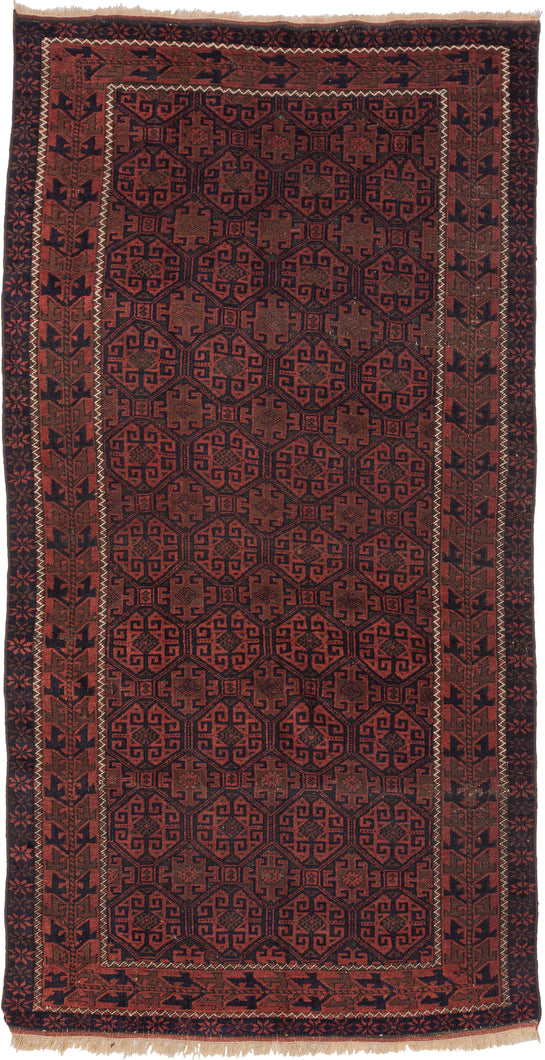A richly patterned Baluch rug with a dense, all-over field of octagonal guls, each filled with intricate, angular motifs. The repeating geometry creates a rhythmic, almost textile-like surface, framed by multiple borders with stylized elements that echo the structure of the field.

Woven in the late 19th to early 20th century, the palette is grounded in deep madder reds and soft abrashed browns, offset by dark indigo outlines. The dyes have mellowed beautifully over time, giving the rug a warm, cohesive ton