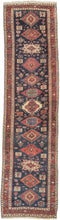 Karadagh It features a series of nested medallions that march down a rich abrashed indigo field. The medallions are rendered in blues, green, red, apricot and aubergine with geometric symbols and figures filling out the negative space. The pile is low and of lush high quality wool.