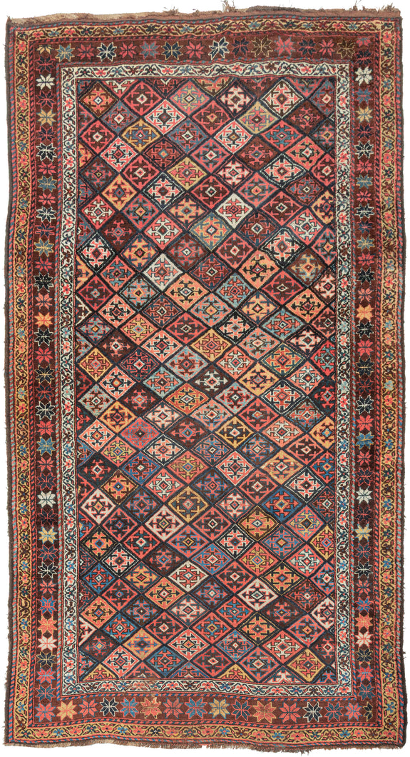 This vibrant rug showcases the bold geometry and saturated color that make these weavings among the most collectible of Kurdish works. It features the classic Jaff interlocking diamond pattern in bright, cheerful colors. The palette is exceptionally rich, with deep madder red, indigo blue, saffron yellow, ivory, and touches of soft green. Each diamond compartment has its own personality, yet the overall effect is one of harmony and movement. The star-filled borders frame the design with balance and complete