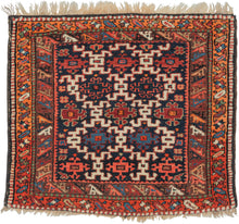 A lively Kurdish village rug handwoven during the second quarter of the 20th Century. It features a bold lattice field of hooked geometric motifs set against a deep indigo ground. The drawing is confident yet playful, typical of small tribal weavings from the Kurdish regions.

The borders animate the composition with stylized birds marching around the field. Along the outer border, beautiful abrash shifts from red to glowing orange, creating a soft tonal transition that evokes the warmth of a sunset.

