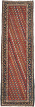 A&nbsp;madder red field densely packed with an all-over diagonal boteh repeat in ivory, navy, gold, teal, and brown forms scattered across the ground in a loose, lively arrangement. The runner reads almost like a textile print at distance and reveals real drawing up close. No two botehs are identical; the color varies row to row, giving the field a warm, animated quality that a more regimented repeat couldn’t achieve.

The main border is a deep navy with a bold reciprocal leaf-and-vine pattern, framed by na