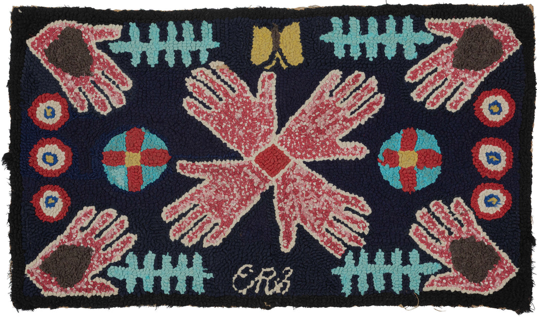 WPA-era American hooked rug from the Southwest US with a central radial motif of stylized hands in red and ivory on a navy ground, surrounded by geometric symbols and a small maker’s initial at the lower edge.