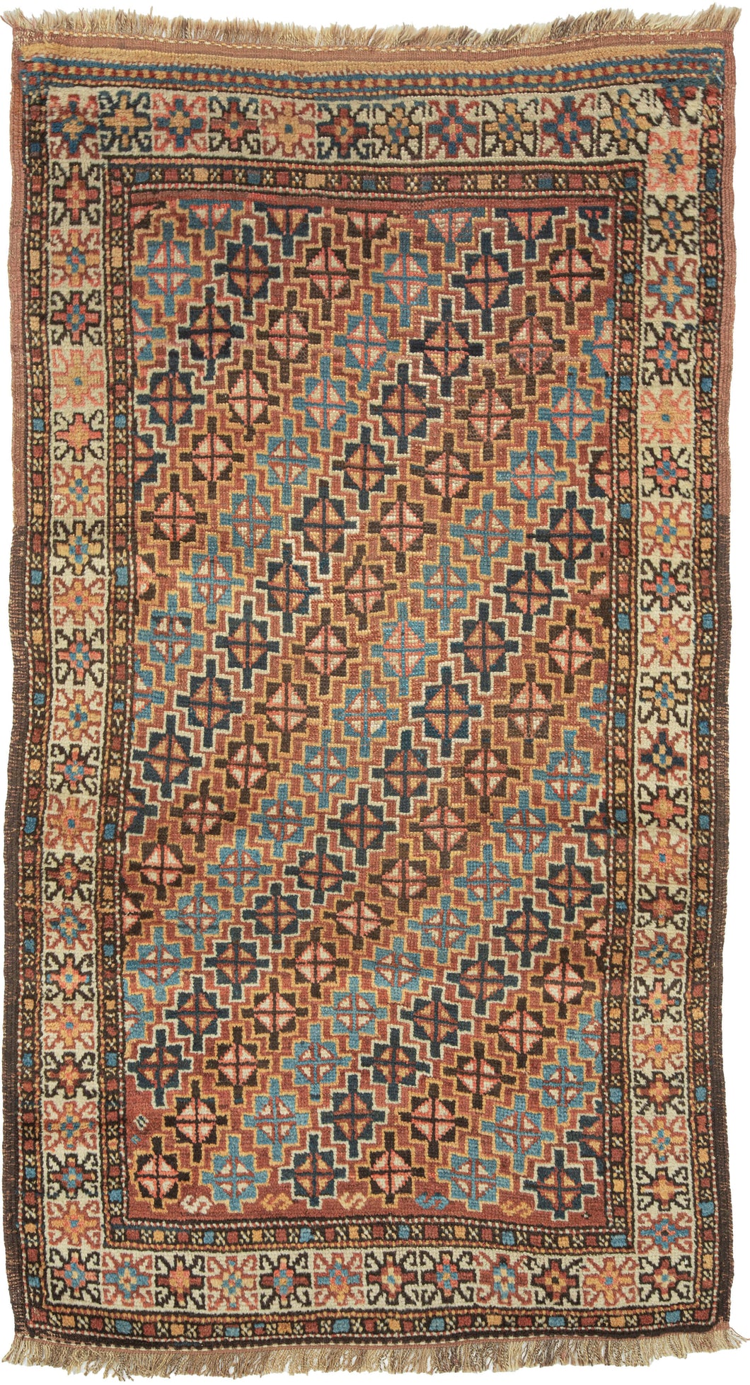 An antique Quchan Kurdish rug woven with an allover field of small stepped geometric medallions in soft salmon, indigo blue, turquoise, ivory, and warm brown. The closely arranged motifs create a lively, mosaic-like surface, framed by an ivory floral border and narrow geometric guard borders.

Quchan rugs were woven by Kurdish communities in the Khorasan region and are admired for their strong tribal drawing, durable construction, and expressive use of color. This example is especially appealing for its com