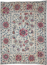 A finely embroidered Nurata suzani featuring a central floral medallion surrounded by scrolling vines, blossoms, and stylized pomegranates. The field is framed by a border of large circular rosettes that echo the central motif and create a balanced architectural composition.
