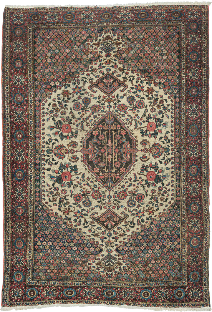 This finely woven Bakhtiari rug is distinguished by its elegant ivory medallion field framed by richly ornamented millefleurs corner spandrels. Graceful vinery and abundant gul farang (“foreign flower”) cabbage roses fill the composition, creating a refined balance between geometric structure and naturalistic floral ornament.