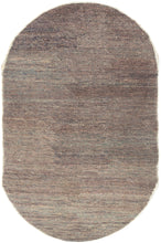 This unusual Chinese rug reflects an inventive approach to material reuse and modern design. Its oval shape and softly variegated surface are woven from a blend of reclaimed yarns to create a subtle, almost painterly texture that shifts between muted mauve, slate, and mineral blue tones. The fine mosaic of color and understated abstraction evoke the spirit of Art Deco modernism while remaining deeply tactile and organic
