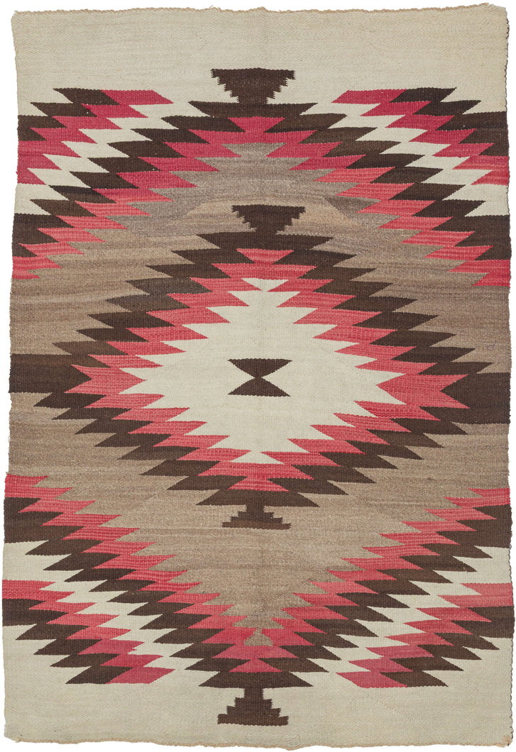 This bold&nbsp;vintage Navajo weaving is defined by its graphic composition and striking palette. A large serrated diamond anchors the design, while rhythmic stepped forms and broad expanses of natural gray wool create a dynamic interplay of movement and negative space.