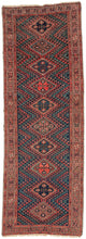 A richly colored antique Kurdish runner with a dramatic dark field and a vertical sequence of stepped diamond medallions. Each medallion contains a bold four-part floral form, set within a field of angular zigzag bands and small hooked motifs in madder red, deep indigo, soft rose, aubergine, and green.

The rug has a strong tribal character, with a narrow format, saturated color, and confident geometric drawing. The repeated diamond medallions create a clear central rhythm, while the surrounding serrated fo