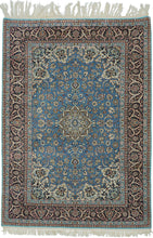 This elegant vintage Nain rug showcases the refined floral artistry that has made these weavings among the most admired of workshop carpet traditions. A luminous sky-blue field is centered by an intricate ivory and camel medallion, surrounded by a graceful lattice of scrolling arabesques, delicate blossoms, and finely drawn palmettes. The richly contrasting midnight navy border frames the composition beautifully, adding depth and sophistication.
