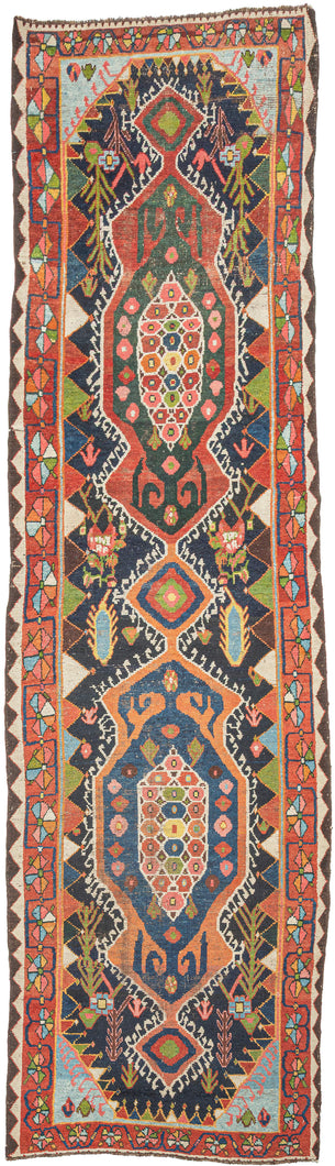 Bakhtiari Gabbeh runner from Southwest Persia with stepped medallions, geometric and stylized floral motifs in coral, indigo, teal, and ivory, arranged in a vertical layout with patterned borders.