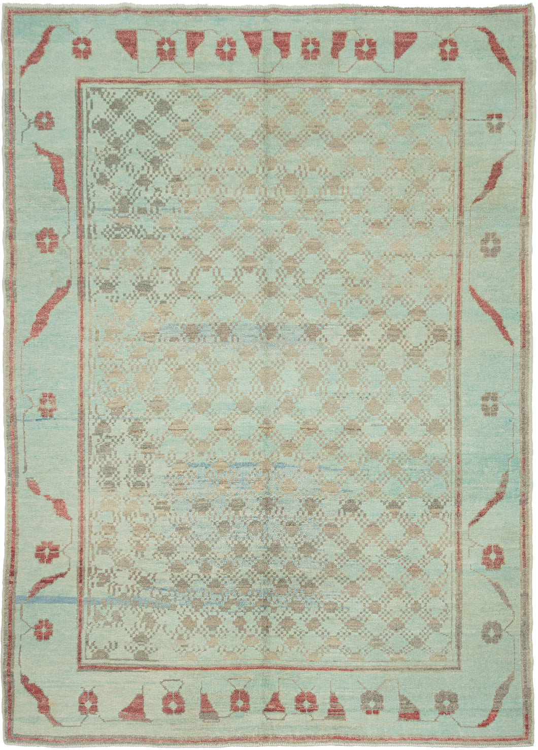 A wonderfully unusual handwoven rug with a soft aqua ground and an intricate allover network of small geometric forms in taupe, gray, and faded blue. The dense central field is surrounded by a much more open border populated with quirky, almost pictographic motifs in brick red and charcoal. 