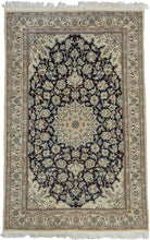 This elegant vintage Nain rug reflects the refined craftsmanship and timeless floral aesthetic for which these weavings are celebrated. A deep midnight navy field is anchored by an intricate ivory and camel medallion, surrounded by gracefully scrolling arabesques, palmettes, and delicate flowering vines. The luminous ivory spandrels and finely detailed floral borders create a striking contrast, giving the composition exceptional clarity and balance.