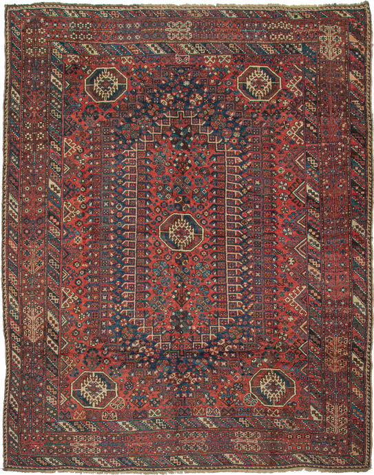 Khamseh rug featuring a strong geometric central design with octagons in various sizes in a palette of red, blue, green, yellow, ivory, and brown. Five large eye-catching octagons are the most prominent and each are filled with the same protection symbol. The field is framed by a main border of floral motifs that are blossoming in pairs flanked by matching minor borders of diagonal stripes each filled with three boxes outlined in contrasting tones.