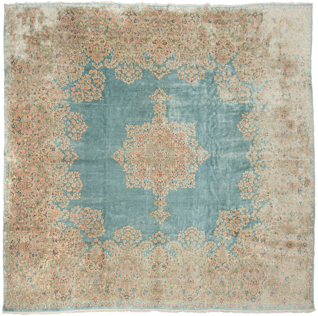 This Kerman rug handwoven during the second quarter of the 20th century.


It features a central medallion floating above an open turquoise ground and framed by a large and elegant border. The medallion and border are both composed of beautifully detailed floral sprays in pastel pinks, reds, seafoam green, copper, and gold and khaki. 