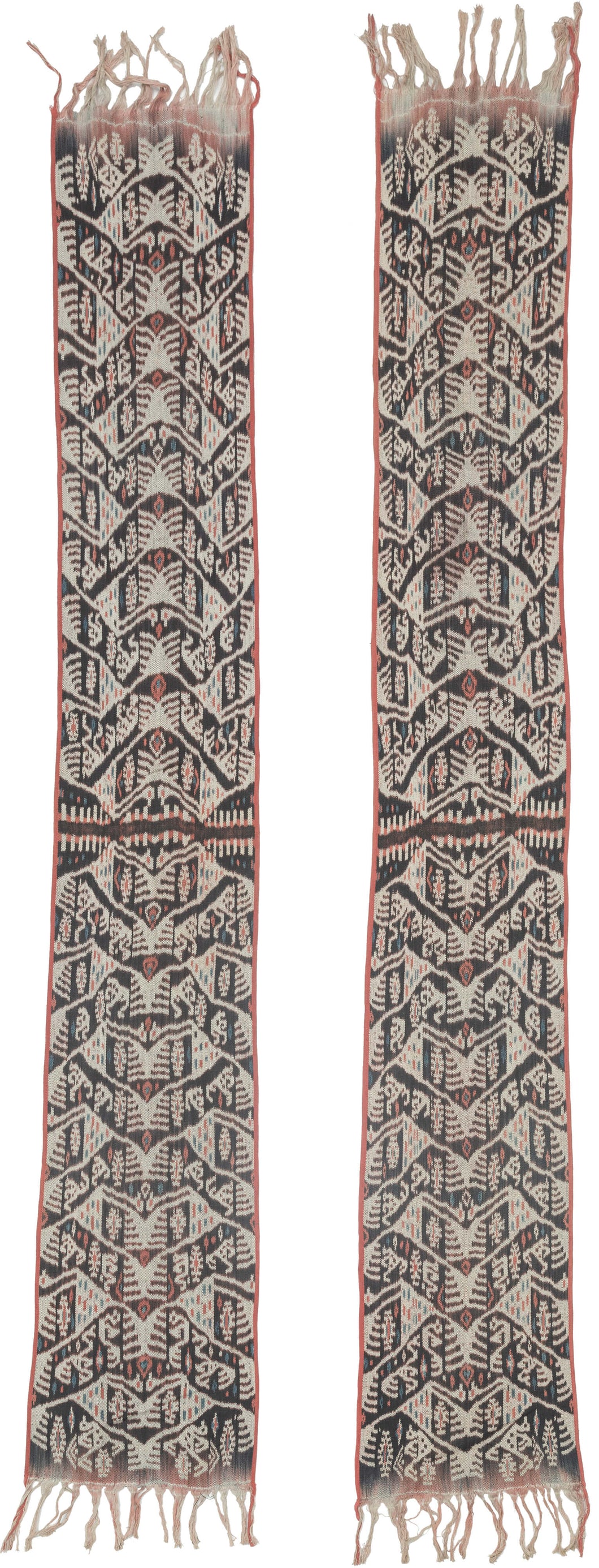 A striking West Timor cotton ikat featuring rhythmic ancestral and vegetal motifs arranged in a vertical progression. Deep brown-black and soft ivory form the primary contrast, accented by subtle coral and indigo details that animate the surface.

The repeating abstracted figural forms and branching motifs reflect Timorese ceremonial weaving traditions, executed in warp ikat with characteristic feathered edges. Finished with traditional fringe and side bindings.