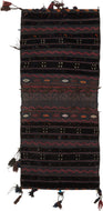 A richly textured saddle bag from Afghanistan with silky wool, woven in a dark, atmospheric palette of deep brown, black, aubergine, red, and indigo tones. The design is arranged in vertical bands with small geometric motifs, zigzag borders, diamond forms, and subtle embroidered details.
