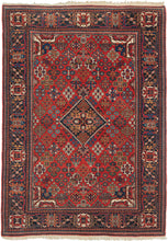 A richly patterned vintage Joshaghan rug with a dense field of highly stylized floral and geometric motifs surrounding a dark indigo diamond medallion. The saturated madder-red ground is enlivened by an unusually broad palette of indigo, sky blue, turquoise, green, ivory, apricot, gold and soft coral.