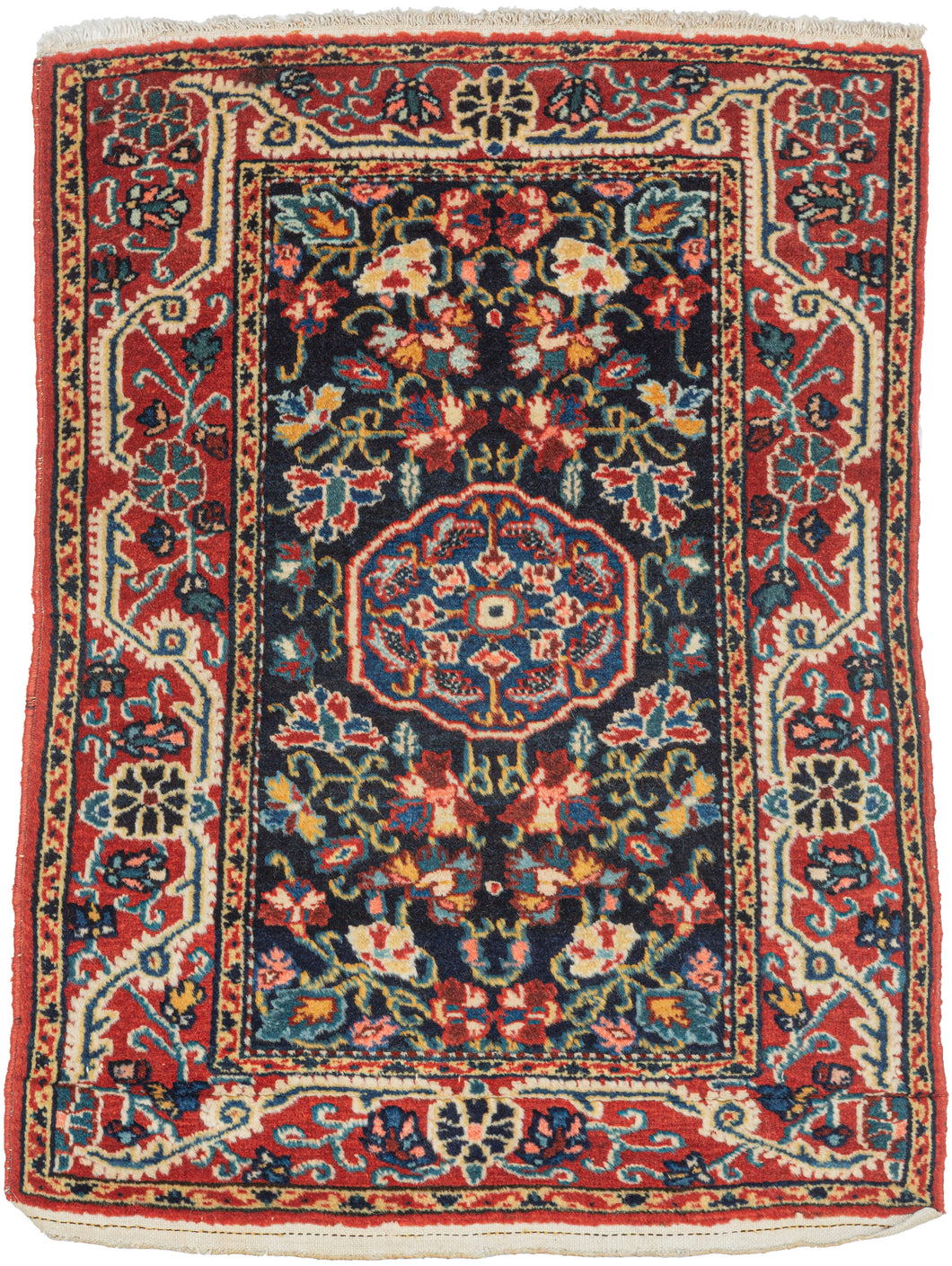 A finely drawn Jozan rug with a deep midnight-blue field filled with scrolling vines, palmettes, and delicate floral motifs surrounding a compact central medallion. The lively botanical design unfolds symmetrically across the field, framed by a richly ornamented red border populated with stylized blossoms and curling tendrils.