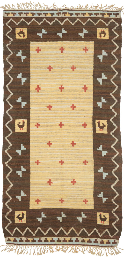 This kilim was handwoven during the middle of the 20th Century in Sweden.

It features red cruciform motifs against a variegated yellow ground with bits of ivory and brown blended in. Framed by a strong variegated brown border with abstracted birds and turquoise 
