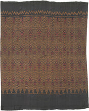 This elegant silk pha sin or traditional tube skirt was handmade northeast Thailand during the middle of the 20th century.

It is a masterful example of mudmee (ikat) weaving from the Isaan region. Woven entirely from fine silk, the textile features a mesmerizing field of diamond motifs arranged in vertical zigzag bands, subtly interlaced with red, gold, and deep aubergine tones against a near-black ground. The effect is one of shimmering depth and rhythmic precision.

The upper and lower bands (hua sinh an