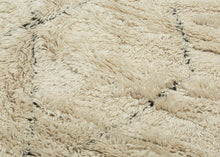 This Beni Ourain rug was woven during the middle of 20th century in the Middle Atlas Mountains of Morocco.

It features a central column of black latticed diamonds on a creamy white ground.&nbsp; Red and brown stripes can be found around the perimeter, most prominently in the striped kilim end borders. Good quality wool in a large format. Often imititated this is the real deal Moroccan shag that Frank Lloyd Wright referred to as "White Giants"&nbsp;