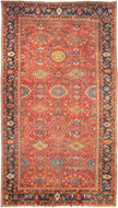 It features a dense and rhythmic allover pattern of palmettes, rosettes, and roving vinery set against a richly saturated madder red field.&nbsp;Lush floral clusters and shield-like medallions in blues, golds, ivory, and greens are symmetrically arrayed across the surface, producing a mesmerizing, layered composition.&nbsp;The deep indigo border is animated with bold palmettes and angular vine scrolls, grounding the exuberant interior with contrast and balance. This carpet’s large format and harmonious pale
