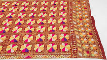 Phulkari is a traditional folk embroidery style from the Punjab region, which spans both India and Pakistan. It is composed of colorful silken thread atop rough cotton cloth.&nbsp;This Phulkari was embroidered in silk floss on multiple red cotton strips and features a striking composition of kaleidoscopic floral medallions arranged in a dense grid. Finished with skirt borders of interlocking motifs, including zoomorphic bird-like figures on one end.&nbsp; Highly contrasting tones of fuchsia, saffron, pistac