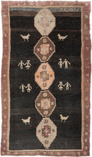 This expressive Kars rug from Eastern Anatolia brings together traditional village weaving with playful, almost naïve figural motifs. Set against a dark brown-black ground, the central row of soft pastel medallions is flanked by charming depictions of birds and pairs of human figures holding hands, giving the piece a narrative and whimsical character.