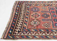 QUCHAN KURD It features a central "Hawzi" motif with three memling guls on the top and the bottom in primary colors of red, yellow and blue with ivory and brown accents on a brick red ground . The "Hawzi" or water tank design is architecturally inspired and references the water reservoirs found in gardens, mosques and village squares. Framed by a series of interesting borders including a main border that shifts from rams heads along the sides to both single running dog and double running dog motifs 