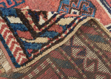 QUCHAN KURD It features a central "Hawzi" motif with three memling guls on the top and the bottom in primary colors of red, yellow and blue with ivory and brown accents on a brick red ground . The "Hawzi" or water tank design is architecturally inspired and references the water reservoirs found in gardens, mosques and village squares. Framed by a series of interesting borders including a main border that shifts from rams heads along the sides to both single running dog and double running dog motifs 