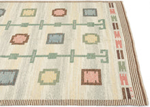This Röllakan kilim was handwoven in Sweden during the middle of the 20th century.

It features a symmetrical layout with soft pastel shades of blue, pink, yellow, and green against an ethereal backdrop. The structured pattern of repeating squares and circles and the totemic green columns create a sense of rhythm and harmony. The background is composed of various marled yarns in ivory, yellow and a grayish green that provide wonderful depth and make the other elements appear to float above it.