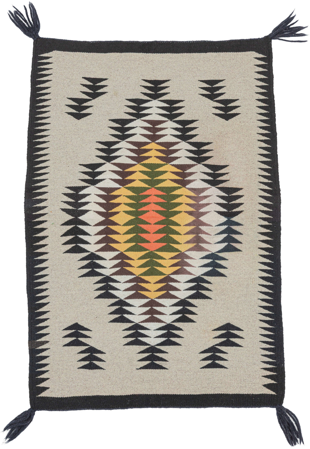 A finely woven vintage Navajo rug with a crisp geometric composition on a natural ivory field. The design centers on a large serrated diamond medallion built from repeating stepped arrow forms in black, white, brown, yellow, green, and salmon.