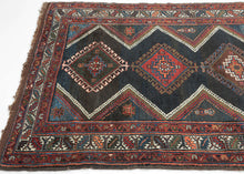 ANTIQUE VERAMIN It features an allover field of four colorful latchhooked diamonds each filled with a memling gul against the deep surmah or blue/black ground and accentuated by striking lightning shaped zigzags. It utilizes a palette of well contrasted, saturated tones including red, orange, multiple blues, greens, brown, and a vivid white that really pops in both the main border and the inner lightning strikes. Nicely finished with extra undyed brown kilim on both ends.