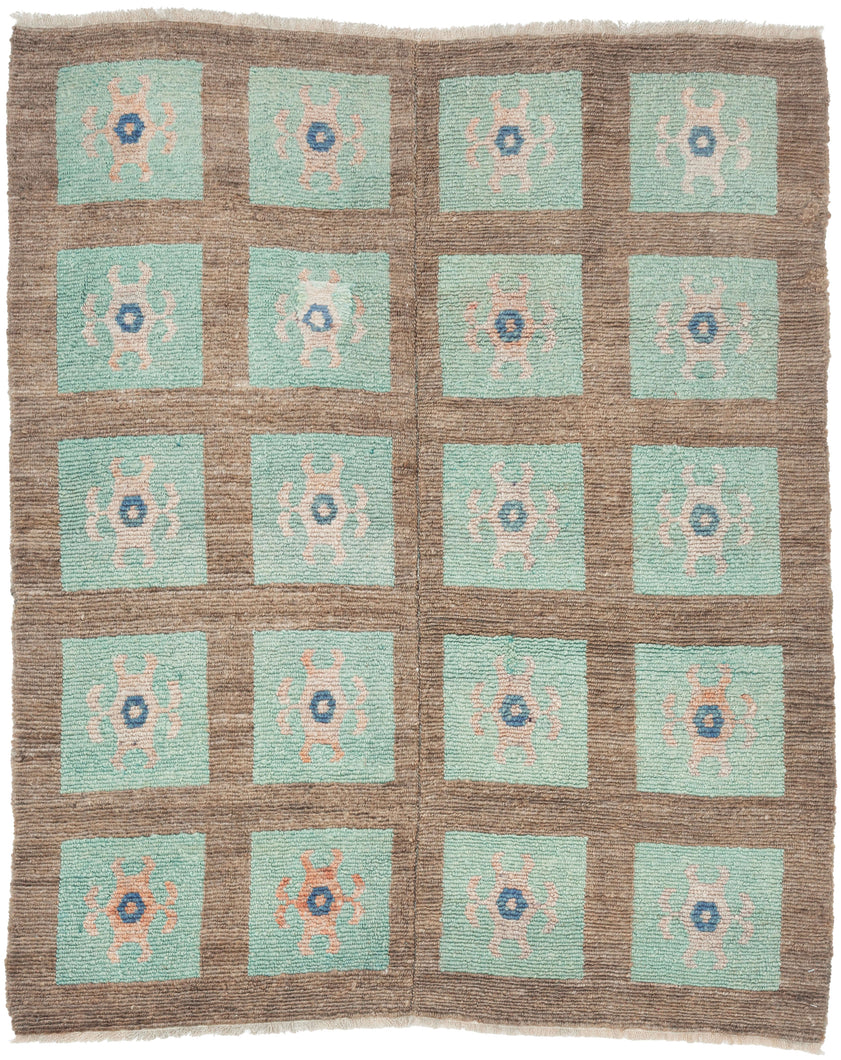A wonderfully graphic vintage latch-hook rug with a repeating grid of aqua panels, each centered by a playful abstract motif in soft blush, salmon, and deep blue. The warm brown ground gives the composition structure while allowing the almost cellular, biomorphic forms to float across the surface.