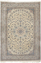 This elegant Nain rug reflects the refined aesthetic that has made these weavings among the most admired of the&nbsp;workshop&nbsp;carpet tradition. Woven on a luminous ivory field, the design centers on a delicate floral medallion surrounded by an exceptionally graceful network of scrolling arabesques, palmettes, and finely drawn flowering vines. A restrained palette of ivory, sapphire, powder blue, taupe, and soft celadon creates an atmosphere of quiet sophistication while allowing the intricate drawing t