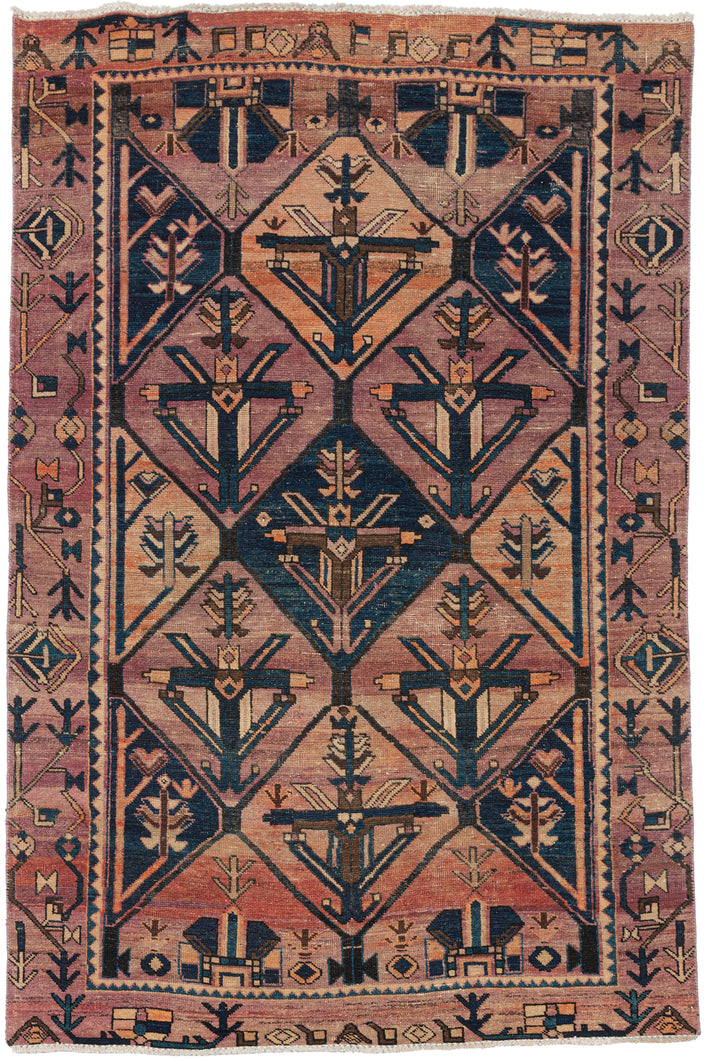 A graphic&nbsp;Kurdish rug with a repeating lattice of stylized tree and arrow motifs. The geometry is crisp, softened by a beautifully faded palette of dusty rose, sand, and deep blue.
