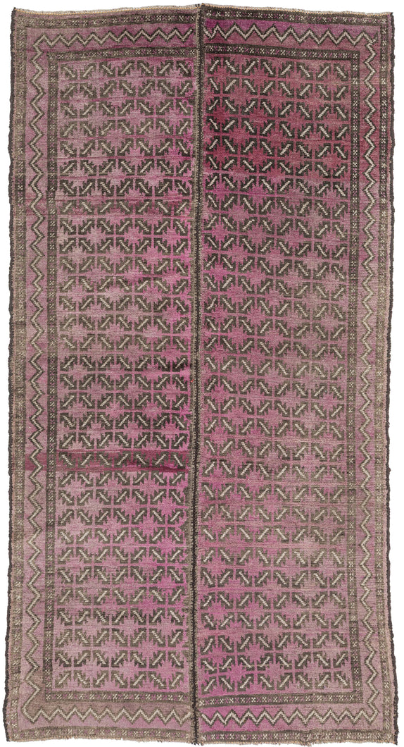 A distinctive Baluch rug featuring an allover lattice of small, repeating arrow and hooked motifs arranged in a tight, rhythmic grid. The rug is constructed in two&nbsp;joined panels and the&nbsp;pattern has a strong directional energy that creates movement across the surface while maintaining a disciplined geometric structure.