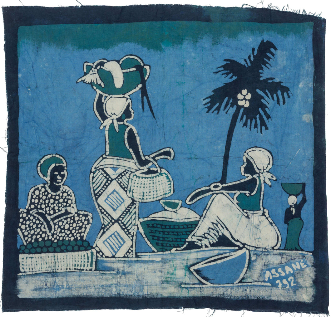A lively West African batik textile signed Assane 292, depicting a village or market gathering beneath a palm tree. Figures are shown seated and standing with baskets, bowls, and vessels, rendered in a bold palette of indigo, turquoise, cream, and deep blue-black.