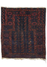 19th century Timuri Baluch rug composed of a wide prayer format often seen in early Timuri rugs. The blue ground mihrab contains a tree of life motif. Some of the serrated leaves on the tree are woven with apricot and aubergine silk. The main border is composed of hexagons with hooked geometric shapes. Outside of the small touches of colorful silk the color palette is subdued and limited to reds, blues, and oxidized browns. 