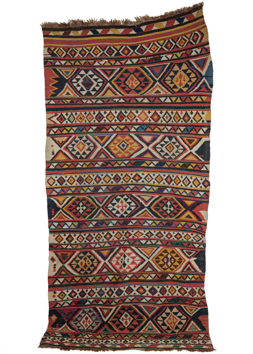 Antique 19th century Caucasian Shirvan area kilim featuring a striped pattern of bold geometric shapes in light and dark blues, peaches, golds, and the rare green.  Interspersed along the sides are small symbols and shapes, filling in the negative space. These wonderful moments of asymmetry really emphasize the handmade quality of this rug. Colorful and joyous, it's bound to bring cheer to any interior. It works well as both a layering piece or stand-alone gem.
