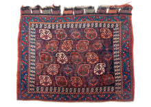 Antique Afshar bagface featuring a field of scrolling vines topped with blossoming botehs in red, stark white, blue, green and a desirable soft burnt orange on a navy ground. It is surrounded by a dinosaur-like primitive bird inner boteh, serrated leaf and rosette outer border which features an exceptional blue. It features the original slit tapestry enclosure that makes use of all the natural dyes in the main weaving for a contrasting zigzag effect.