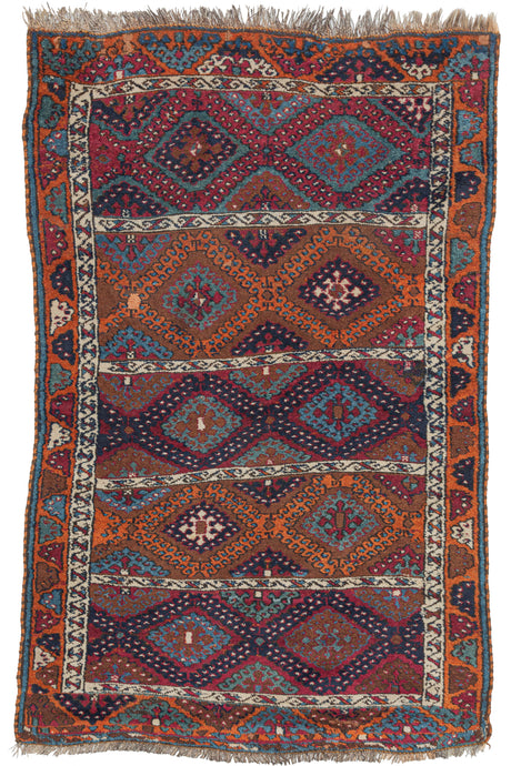 Antique Anatolian Kurdish Sarkisla rug featuring five alternating rows of hooked diamonds which are classic for this special type. Distinguished by both uncommon and unexpected palettes of purplish reds, burnt oranges, navy, cool white, and topaz blue. The end borders continue with half portion of the classic hooked diamonds where the side borders showcase a smaller scale more abstract version of the same form.