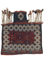 Antique Bakhtiari Salt bag featuring a flatwoven repeat diamond field in madder and indigo with touches of turquoise and apricot. It is framed by a large border of white cotton latch hooked diamonds. The neck showcases one of the same white diamonds as the field which is surrounded by rosettes. It is embellished with lively braided tassels flanking the neck.